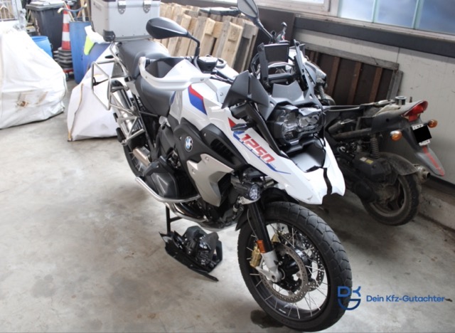 Weiße BMW R 1250 GS mit Unfallschaden, abgestellt in einer Garage